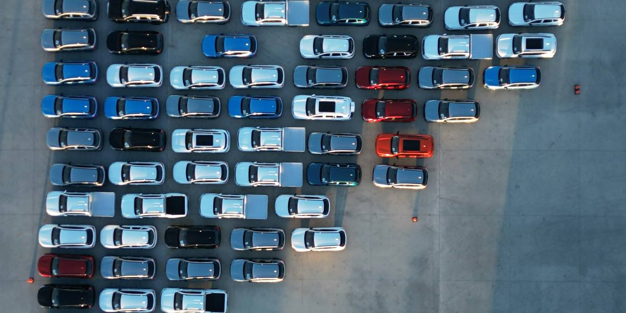 Aerial view of rows of vehicles parked on a dealership lot