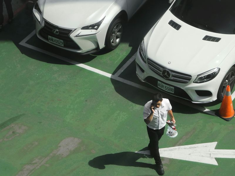 Driver walking through a parking area beside parked vehicles